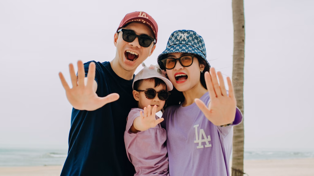 an asian family on a beach posing for a silly photo