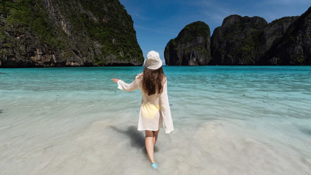 an asian female traveller walking to the ocean